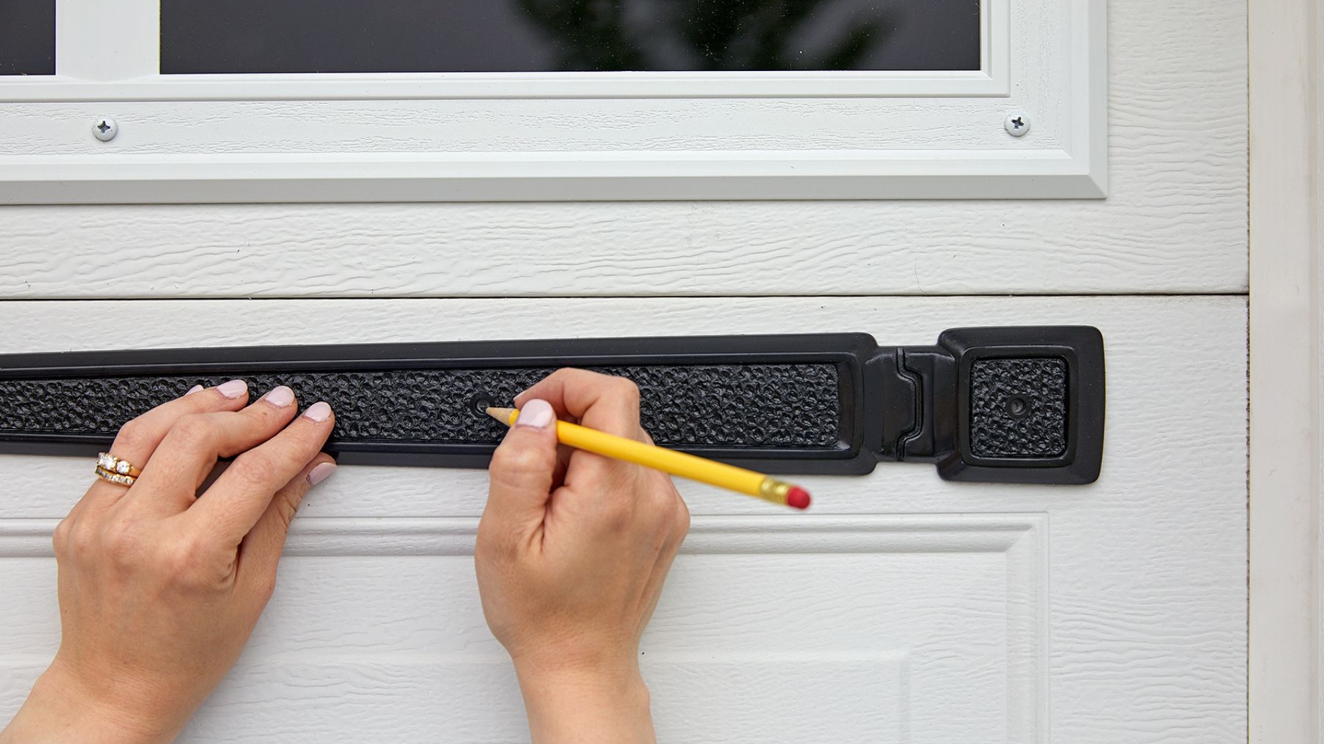 A homeowner installing garage door decorative hardware