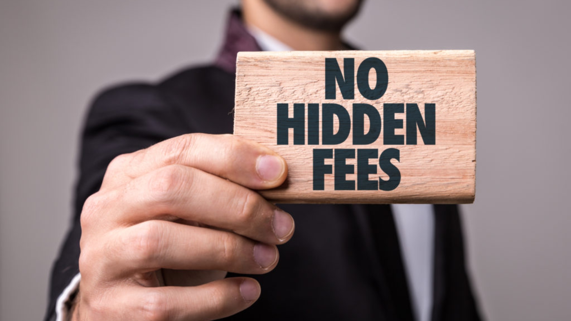 A man holding a signage that says "No Hidden Fees"