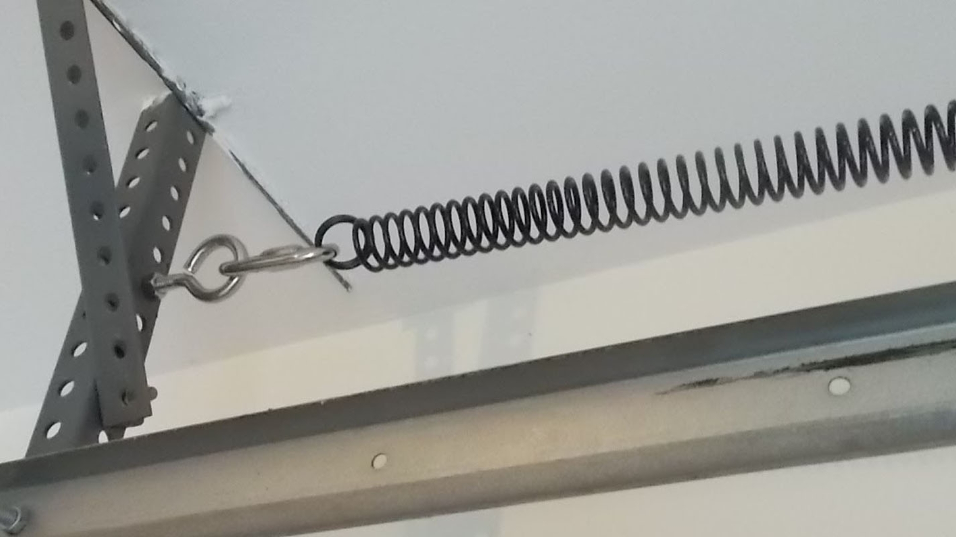 A garage door extension spring being stretched out