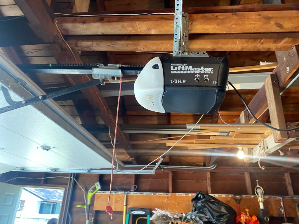 Garage door opener repair showing ceiling-mounted motor