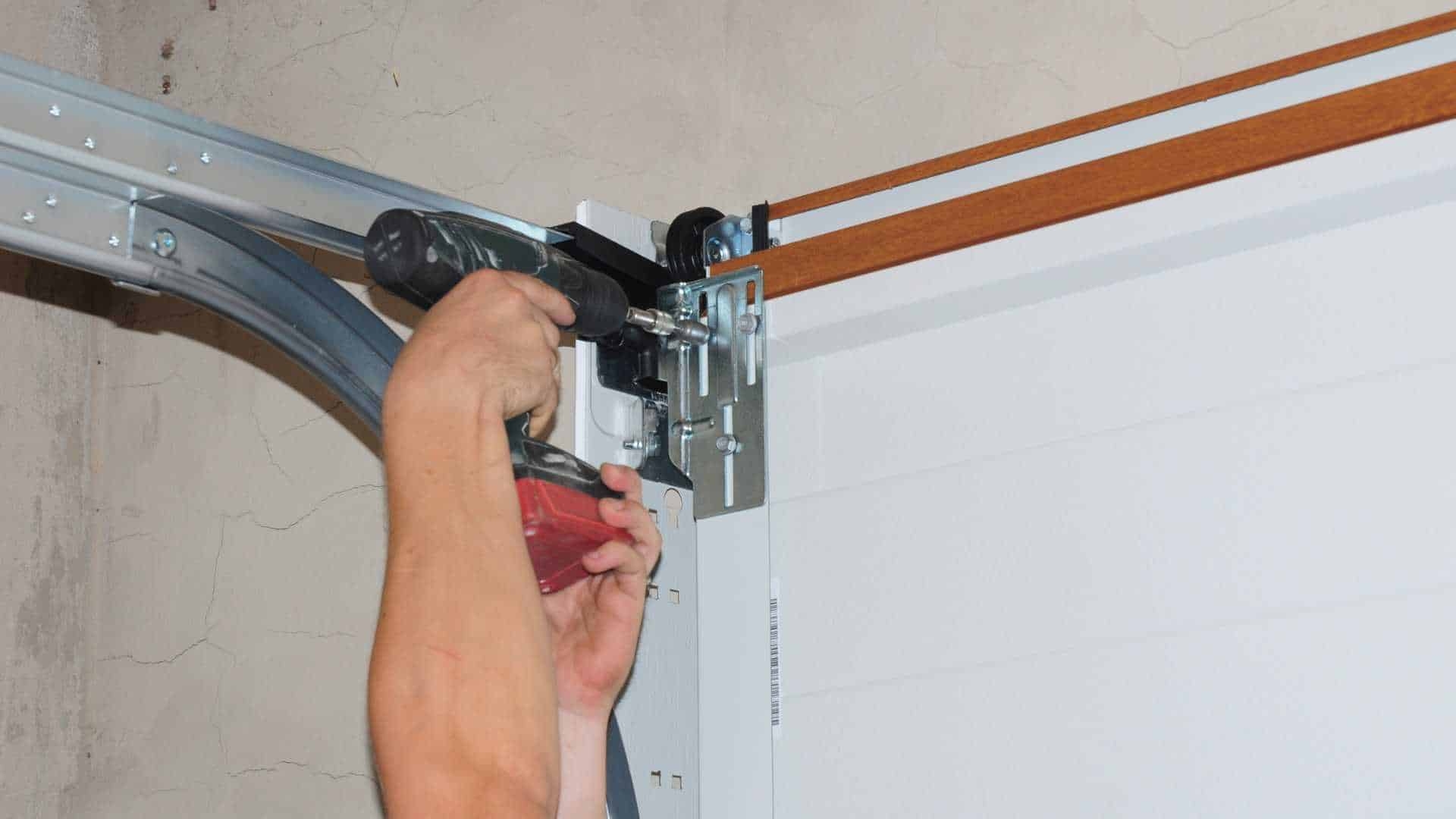 Garage door technician adjusting hardware to fix slow opening problem