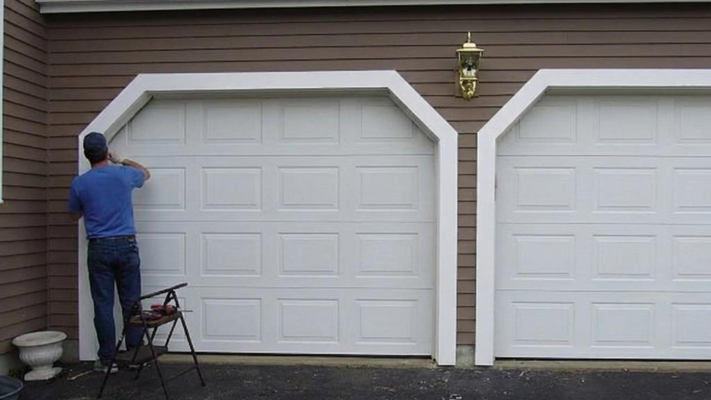 Technician inspecting damaged garage door panels due to wear and tear