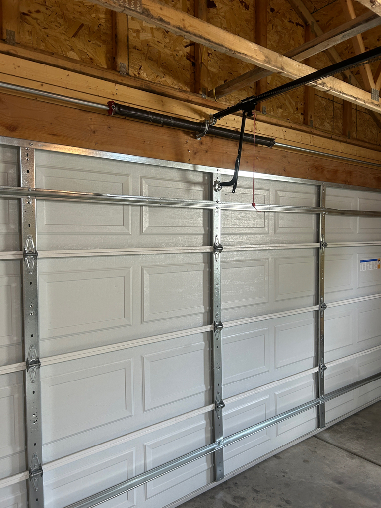 Garage door tune-up inspection of a residential sectional door, torsion spring, and opener