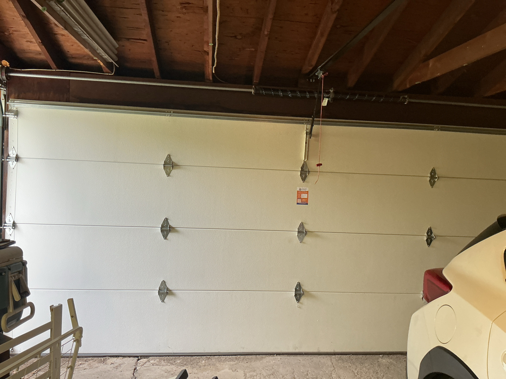 Garage door tune-up showing a residential sectional garage door and torsion spring system.